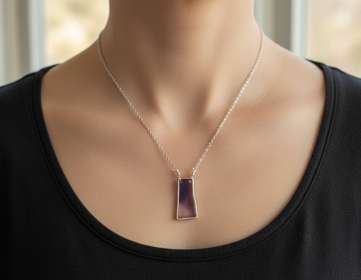 Silver pendant necklace on a wooden surface